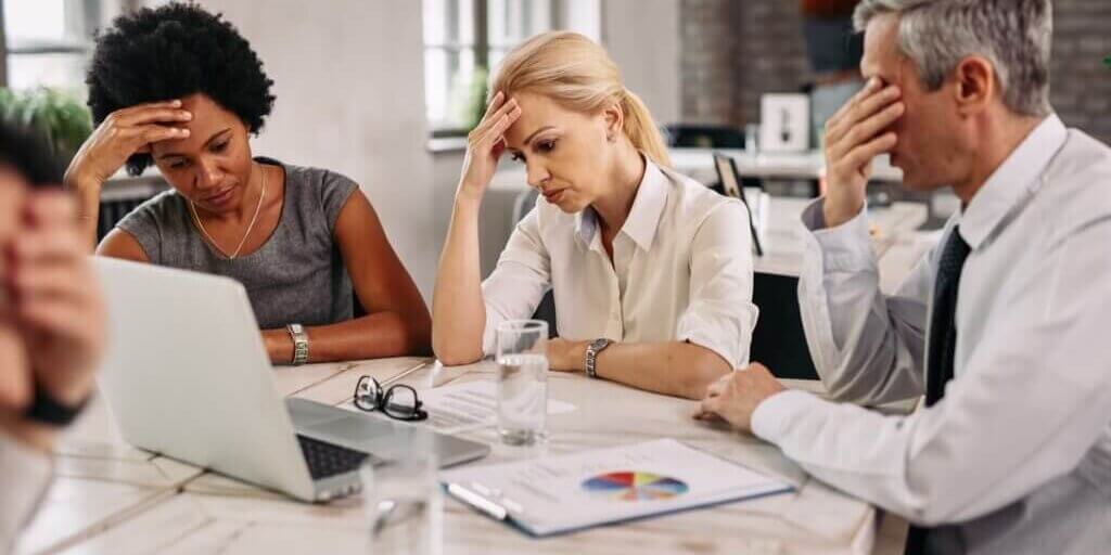 group-business-colleagues-having-headache-while-working-laptop-trying-solve-problems-during-meeting