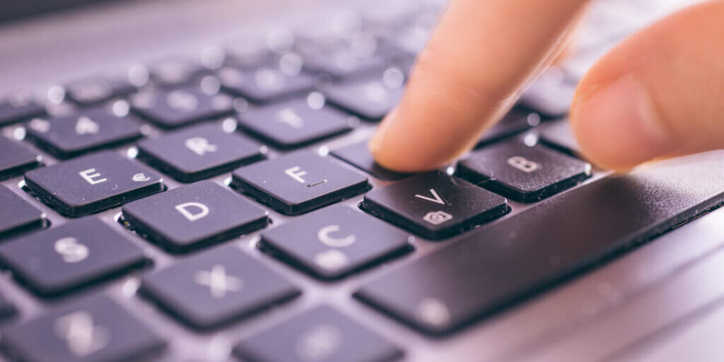 Close up on fingers texting on a computer keyboard