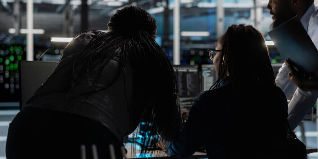 Server farm engineering team implementing and managing data backup solutions. Teamworking data center colleagues identifying and resolving technical errors, ensuring efficient recovery