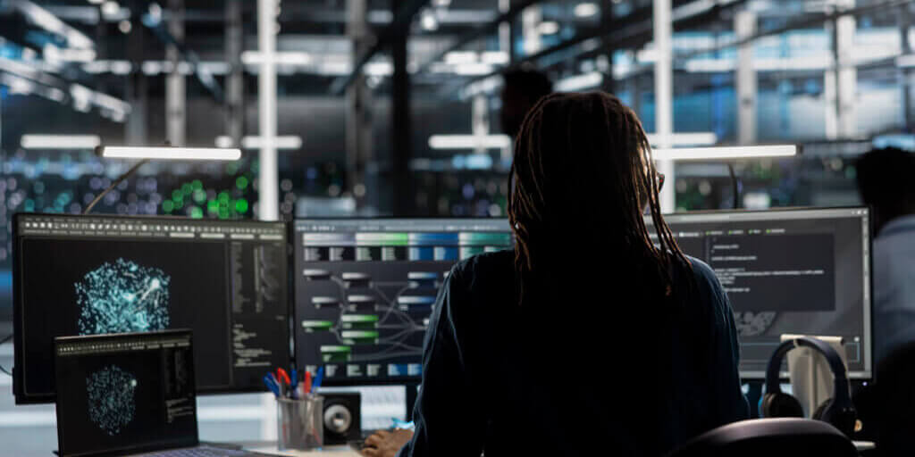 Data center worker using AI deep learning algorithms to analyze large datasets. Server farm technician using artificial intelligence and visual programming to recognize patterns in facility data