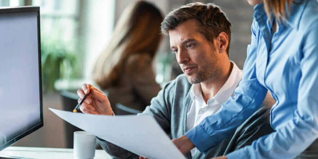 Two business colleagues examining documents while working together in the office.