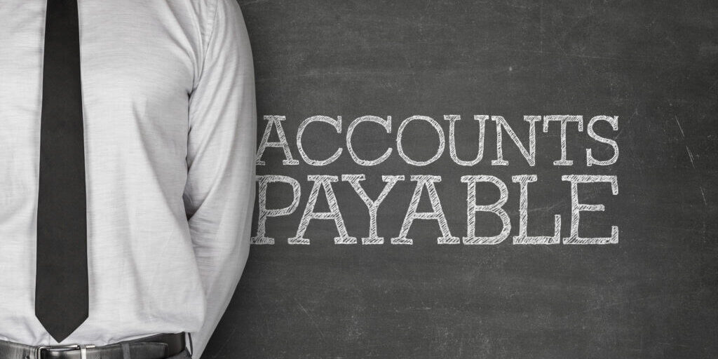 Accounts payable text on blackboard with businessman on side