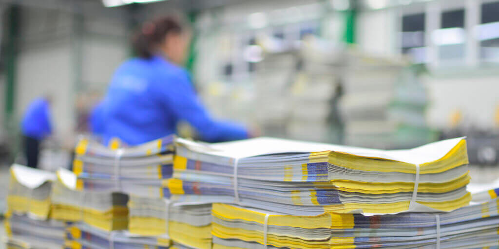 Printed material packets with blur workers at background